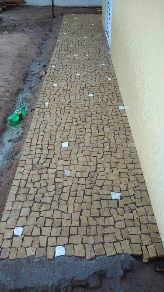 Caminho externo reto com piso em pedras claras